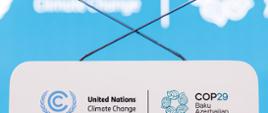 Pusta mównica i dwa skrzyżowane mikrofony. Widoczne logotypy UNFCCC i COP29.