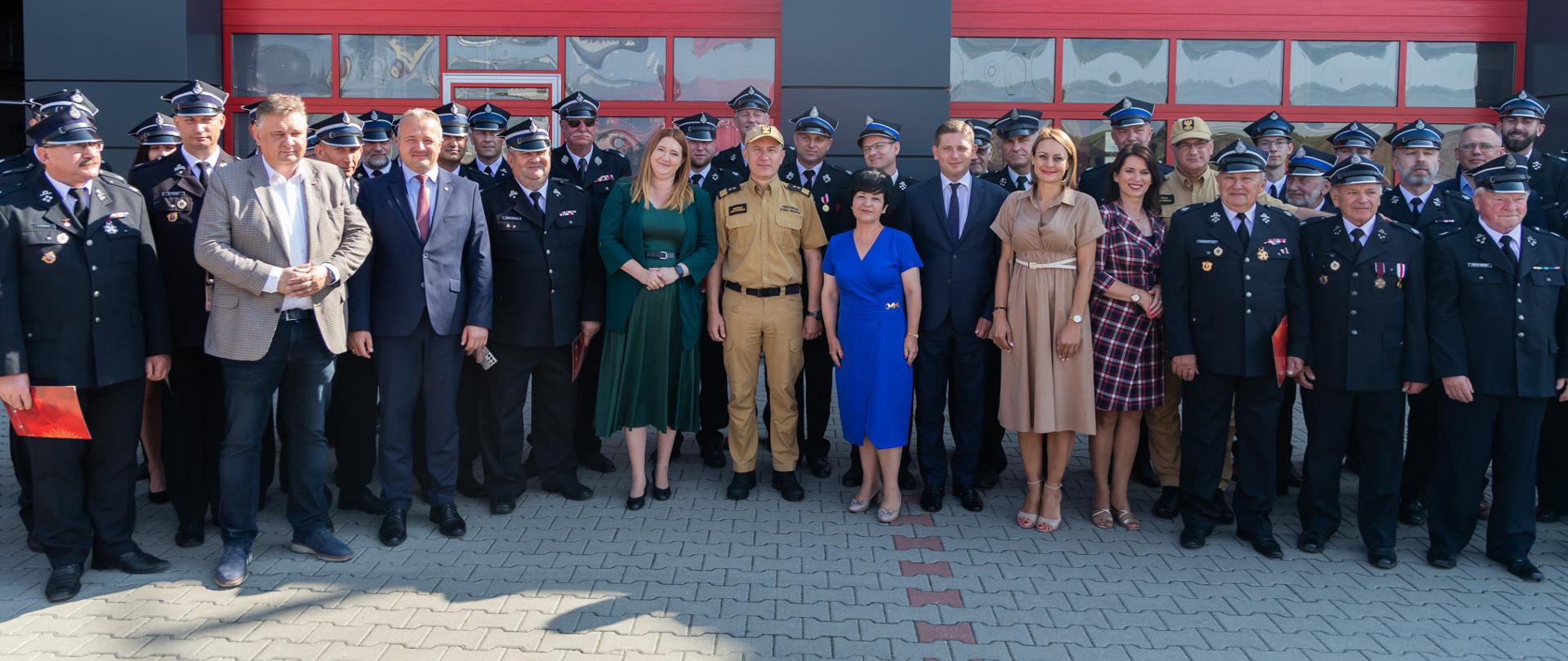 Komendant Główny PSP pozuje do zdjęcia grupowego z druhami i przedstawicielami władz. 