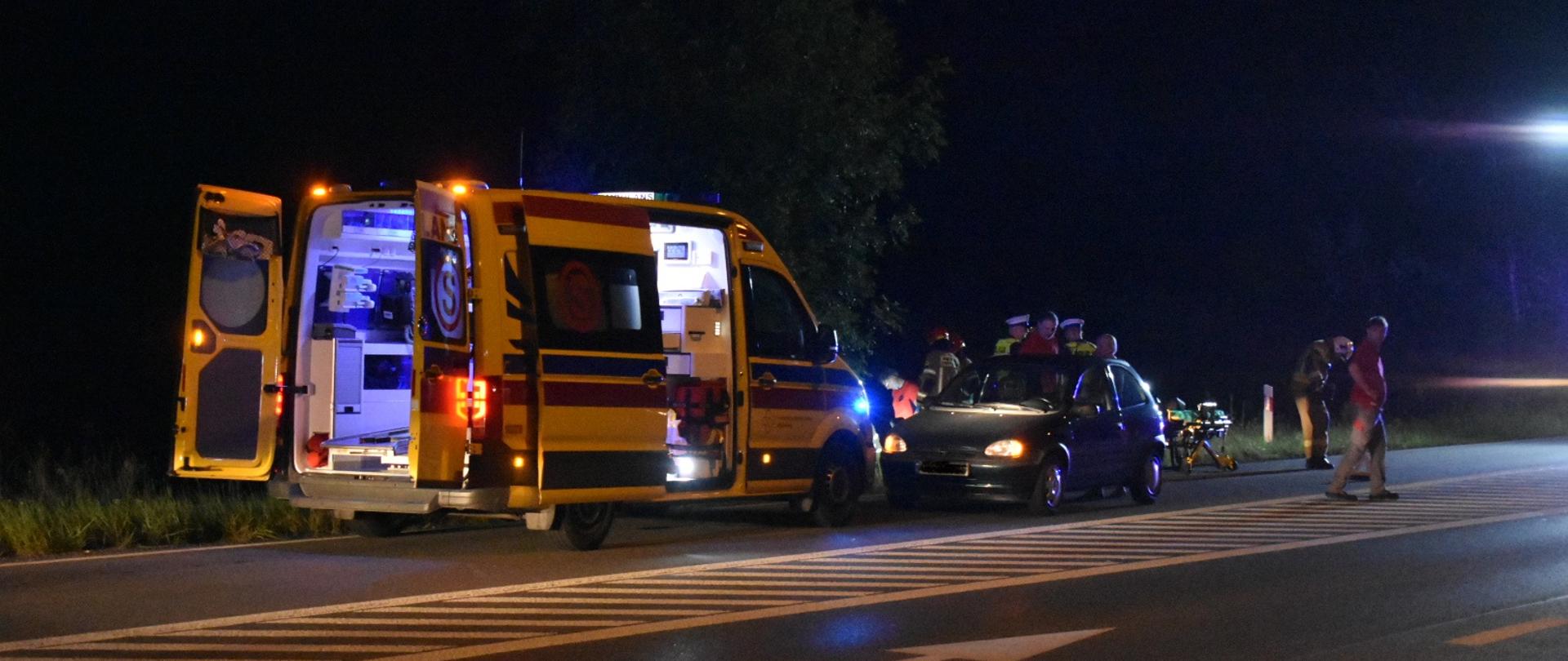 Karetka prze nią samochód osobowy za nim strażacy