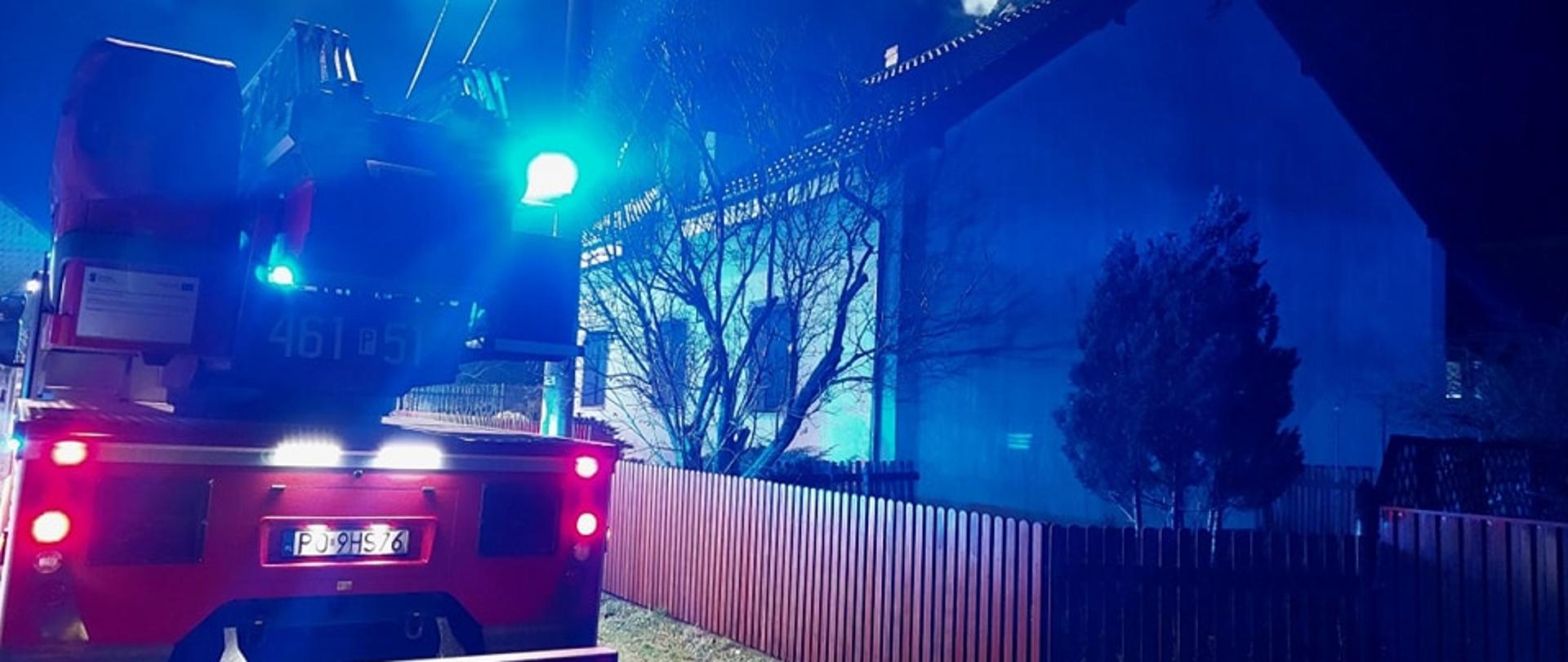 Widoczne miejsce zdarzenia budynek objęty działaniami oraz pojazdy pożarnicze.