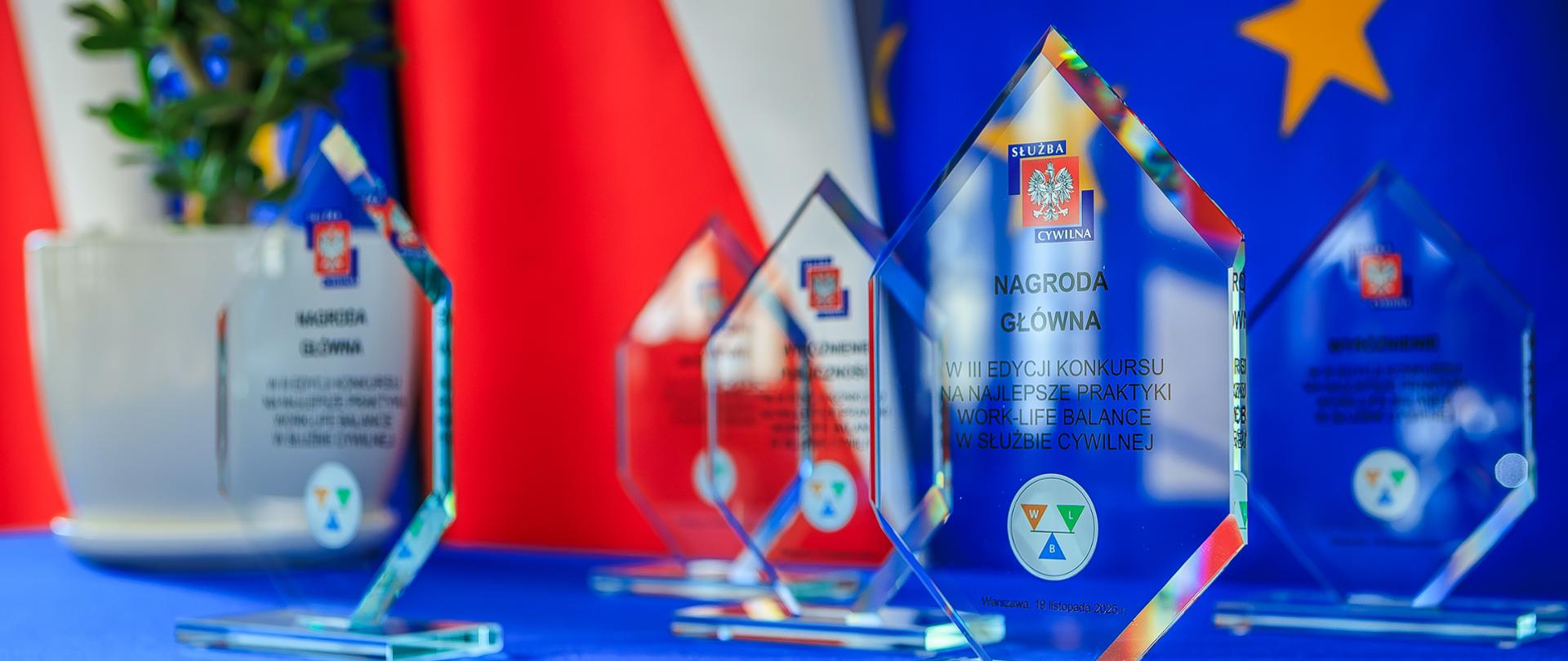 Statuetki dla zwycięzców - przezroczyste statuetki na granatowym obrusie