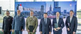 Przedstawiciele służb mundurowych, administracji i instytucji partnerskich pozują do wspólnego zdjęcia podczas uroczystości podpisania porozumienia.