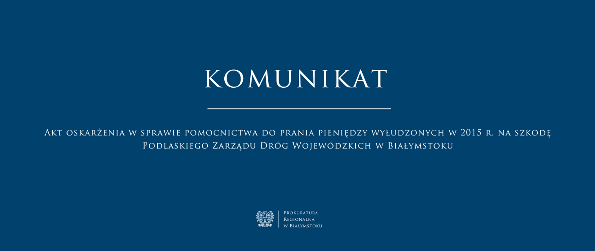 Na przedstawionej grafice widnieje oficjalny komunikat Prokuratury Regionalnej w Białymstoku. Tło jest ciemnoniebieskie, a tekst zapisany jest białą czcionką. Treść komunikatu: KOMUNIKAT Akt oskarżenia w sprawie pomocnictwa do prania pieniędzy wyłudzonych w 2015 r. na szkodę Podlaskiego Zarządu Dróg Wojewódzkich w Białymstoku. Na dole grafiki widnieje logo polskiego orła oraz napis: Prokuratura Regionalna w Białymstoku