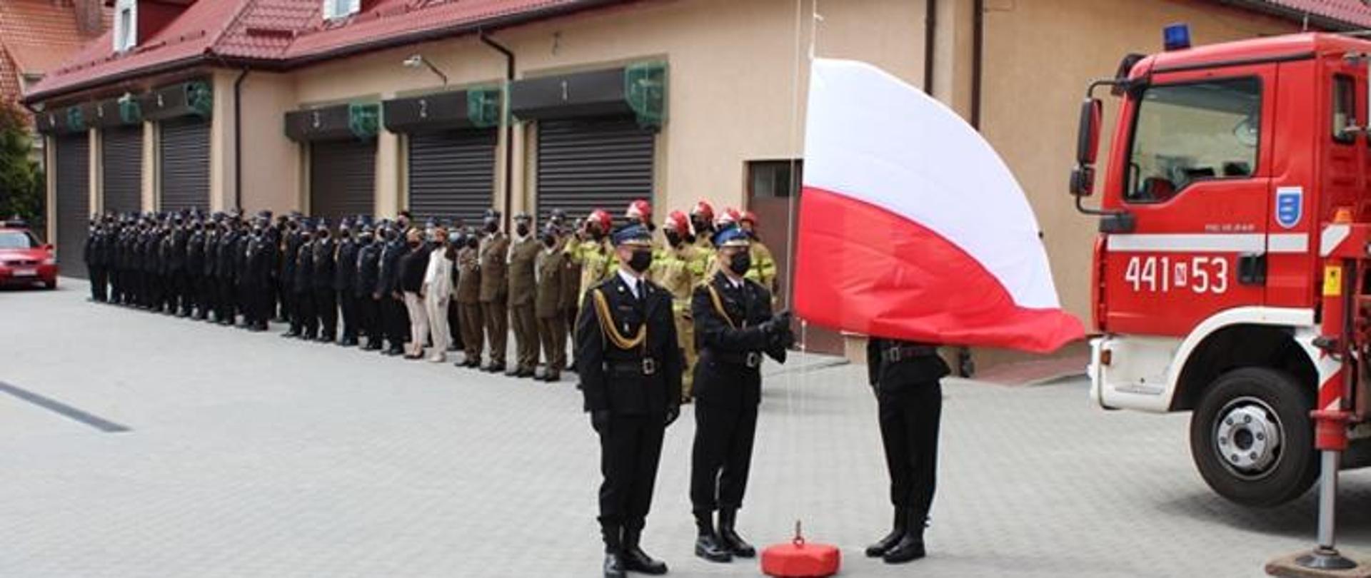 Zdjęcie przedstawia poczet flagowy KP PSP w Giżycku, który przygotowuje się do podniesienia flagi RP na maszt