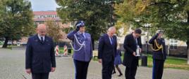 Wojewoda pomorski zaproszeni goście skinęli głową przedstawiciele Policji oraz Państwowej Straży Pożarnej oddają honor na ziemi leży wieniec oraz znicze.