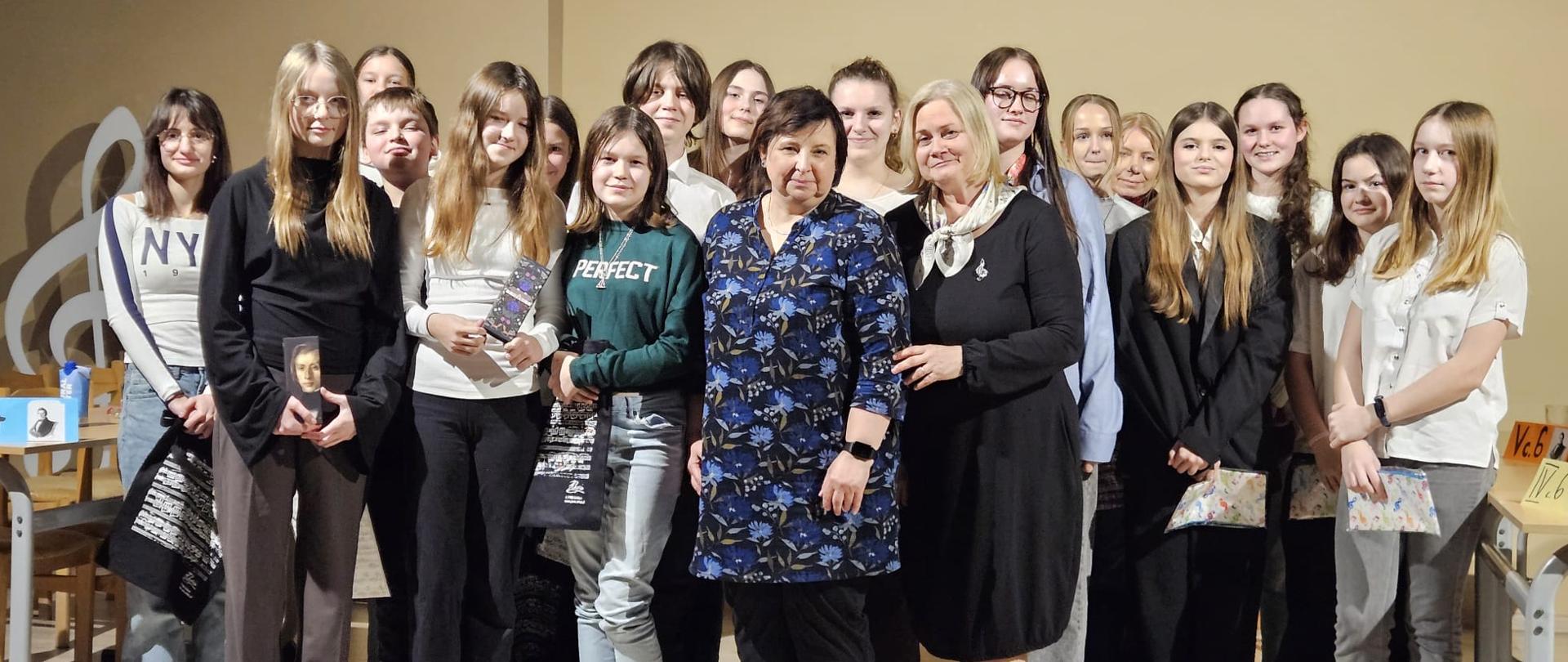 Uczniowie i nauczyciele stojący na scenie