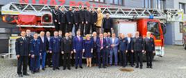 na tle drabiny mechanicznej straży pożarnej Tychach: Zastępca Śląskiego Komendanta Wojewódzkiego, Komendant Miejski wraz z zastępcą. Przedstawiciele władz samorządowych, kierownictwo komend Policji, Straży Miejskich oraz Ochotniczych Straży Pożarnych