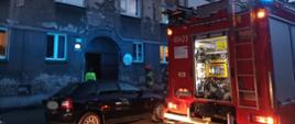 Ulica przed budynkiem w którym doszło do zdarzenia, wóz strażacki i ratownicy
