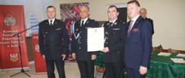 Zdjęcie przedstawia wręczających i odbierających akt włączenia jednostki OSP Brdów do KSRG na kolejne 5 lat