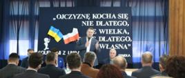 Minister Przemysław Czarnek mówi do mikrofonu, przed nim siedzą uczestnicy spotkania.