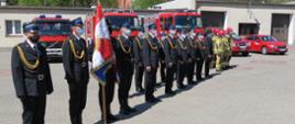 Zdjęcie przedstawia funkcjonariuszy Komendy Powiatowej PSP w Brodnicy podczas uroczystego apelu z okazji Dnia Strażaka. Na pierwszym planie dowódca JRG, oraz poczet sztandarowy, w tle pojazdy Komendy Powiatowej.