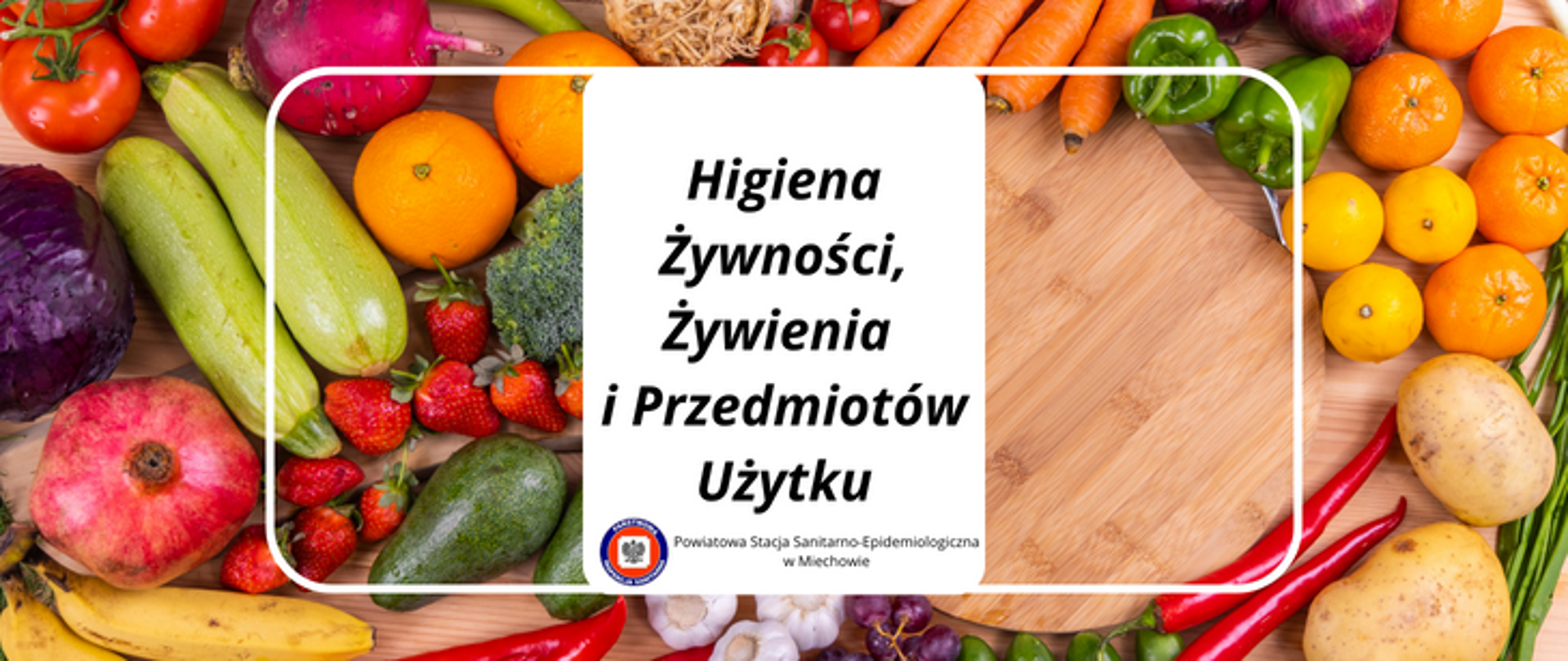 Na tle warzyw i owoców na środku znajduje się biały prostokąt z napisem Higiena Żywności, Żywienia i Przedmiotów Użytku. W dolnej części białego pola znajduje się logo Państwowej Inspekcji Sanitarnej oraz napis Powiatowa Stacja Sanitarno-Epidemiologiczna w Miechowie.