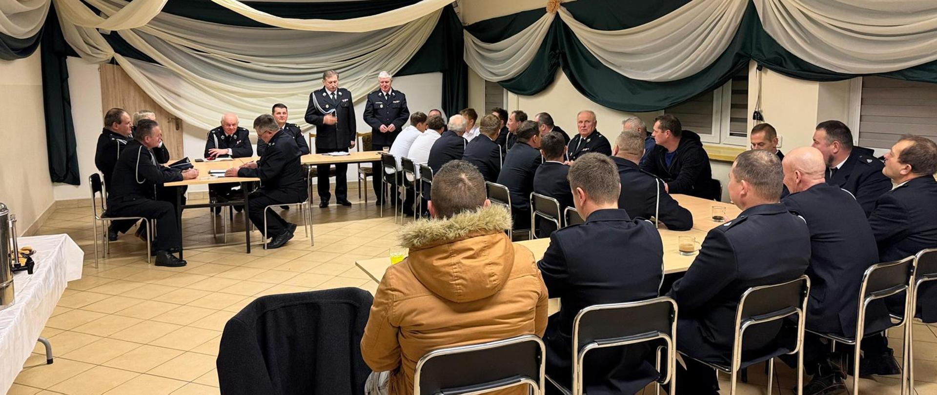 Walne zebranie sprawozdawczo-wyborcze osp niemstów, na zdjęciu widoczni strażacy siedzący przy stołach konferencyjnych w czasie zebrania