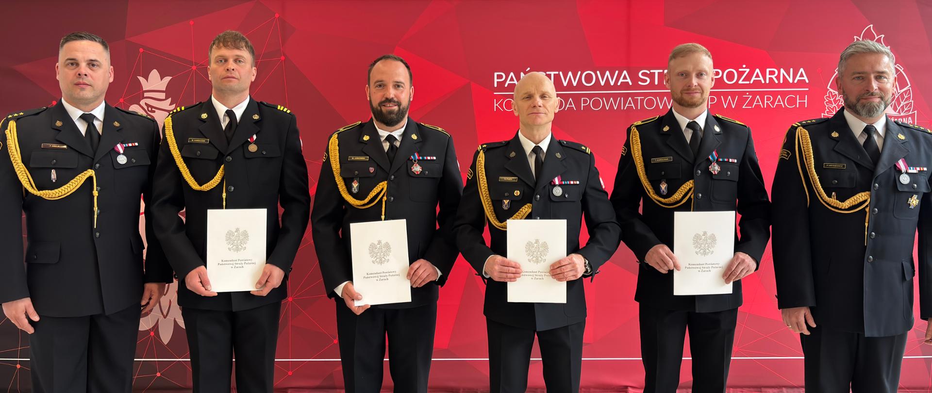 Uroczyste wręczenie nagród jubileuszowych w KP PSP w Żarach - szereg nagrodzonych z komendantami w mundurach wyjsciowych 