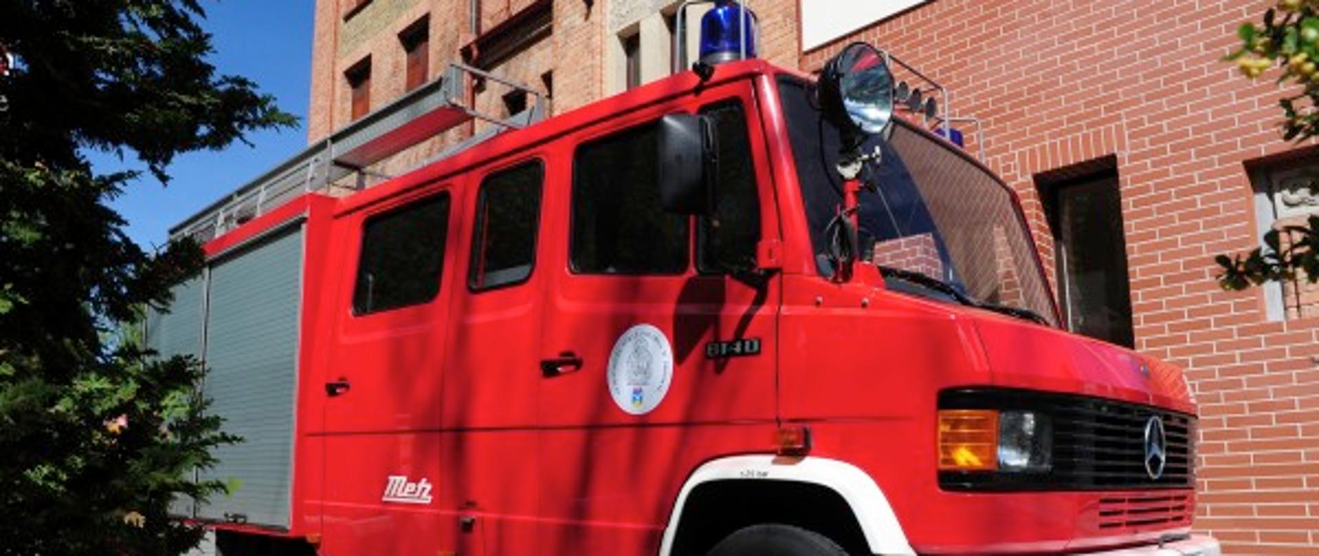Samochód lekki ratowniczo gaśniczy mercedes w kolorze czerwonym stojący przy budynku Komendy Miejskiej PSP w Sopocie