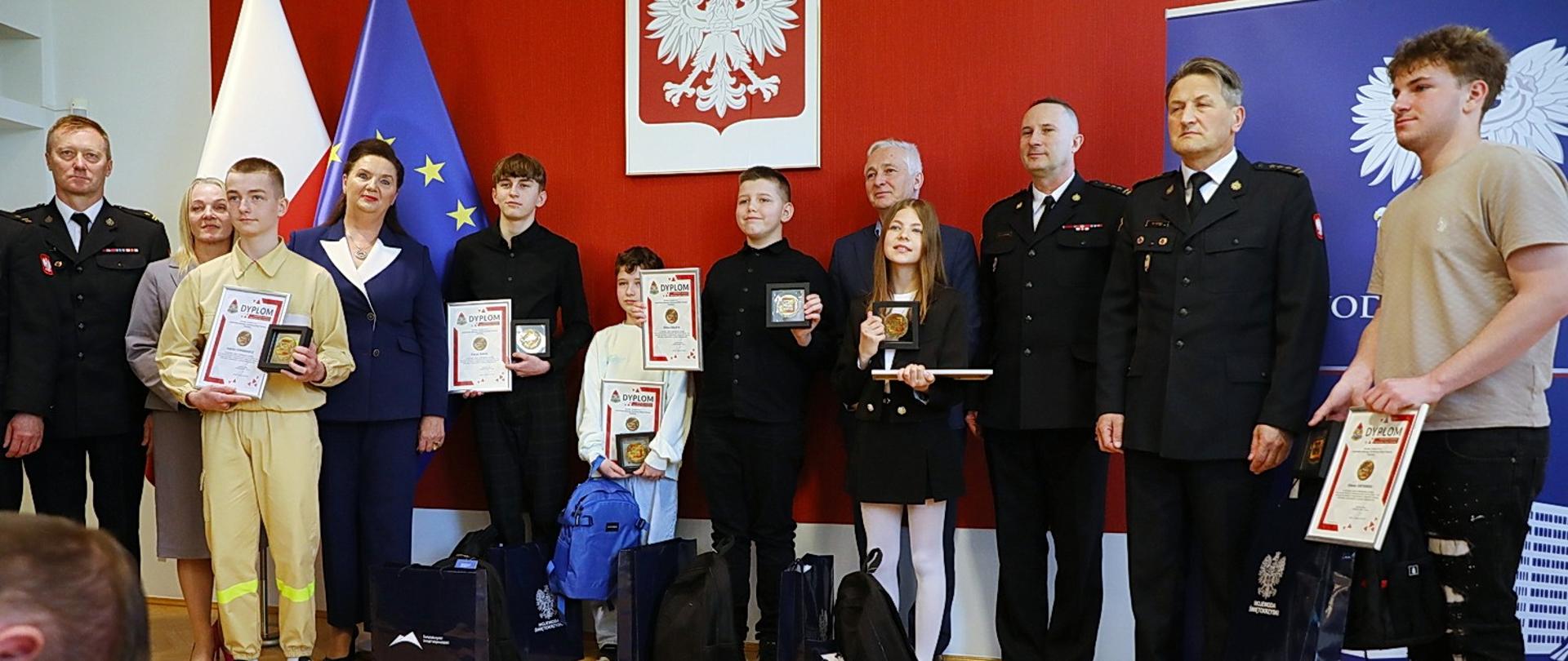 Pamiątkowe zdjęcie grupowe. Wszyscy odznaczeni odznaką Iuvenis Forti z przedstawicielami ŚUW i PSP oraz przybyłymi gośćmi.