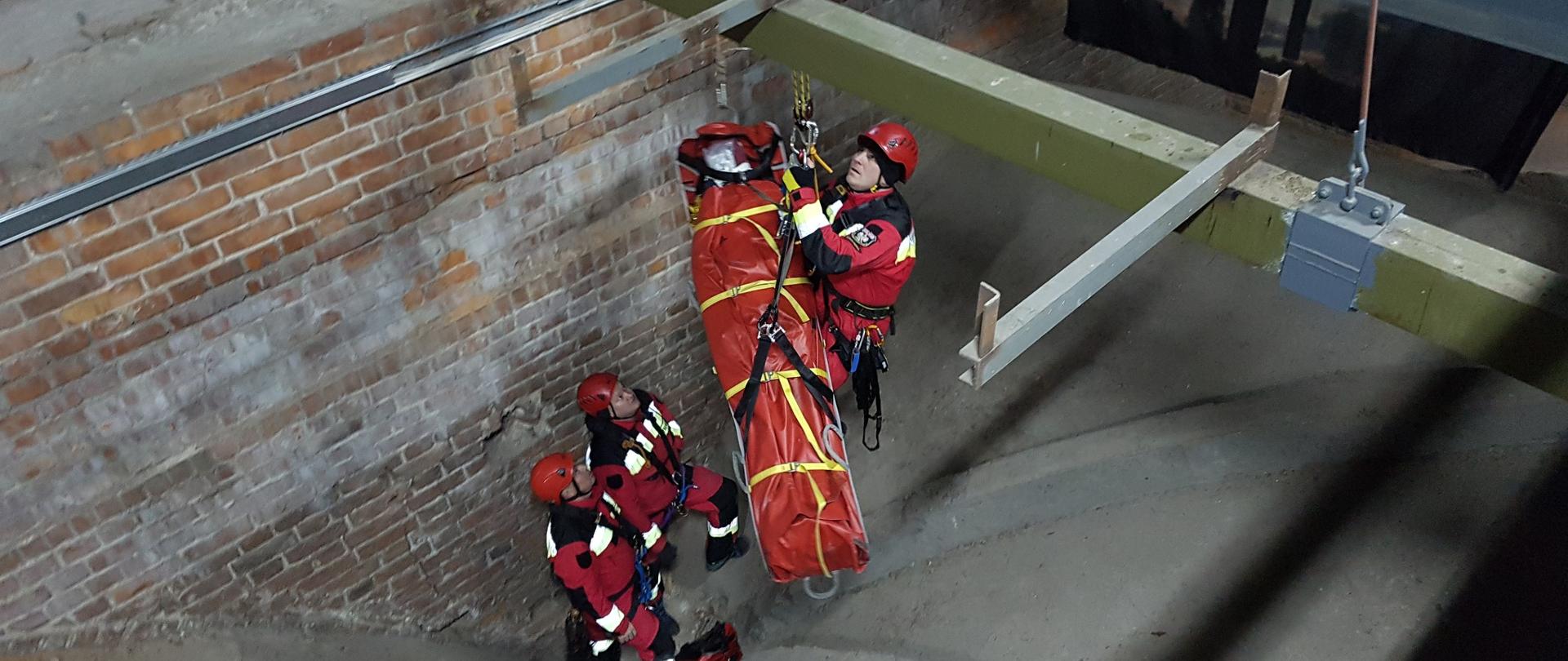 Strażacy ewakuujący osobę poszkodowana na noszach z zagłębienia