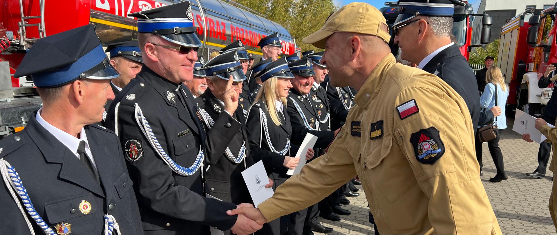 Dwóch strażaków w uścisku dłoni 