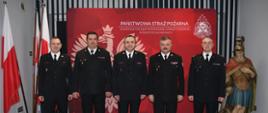 Od lewej stoją, zastępca dowódcy jednostki ratowniczo-gaśniczej, zastępca komendanta, strażak, który odchodzi na emeryturę, komendant miejski oraz dowódca jednostki ratowniczo-gaśniczej