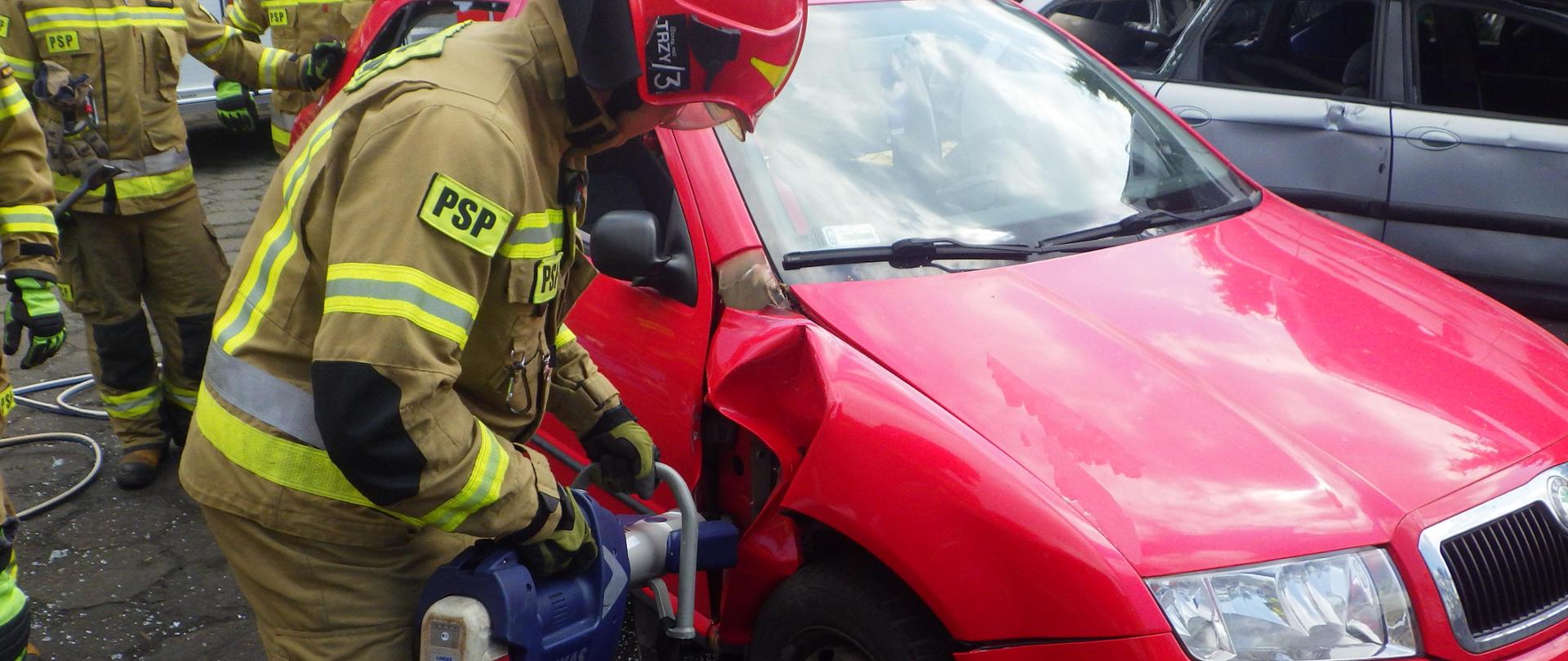 Strażak rozgina karoserię przy użyciu rozpieracza 