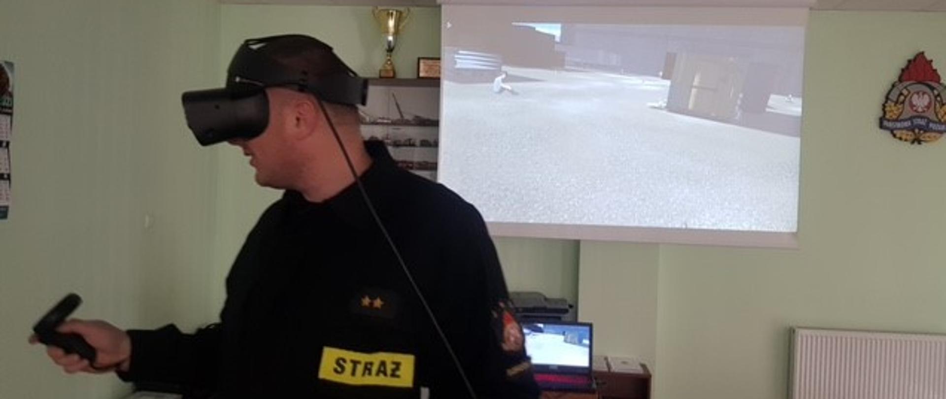 Na zdjęciu widać strażaka korzystającego z Platformy Wirtualnej Symulacji. Jest ubrany w gogle VR. 