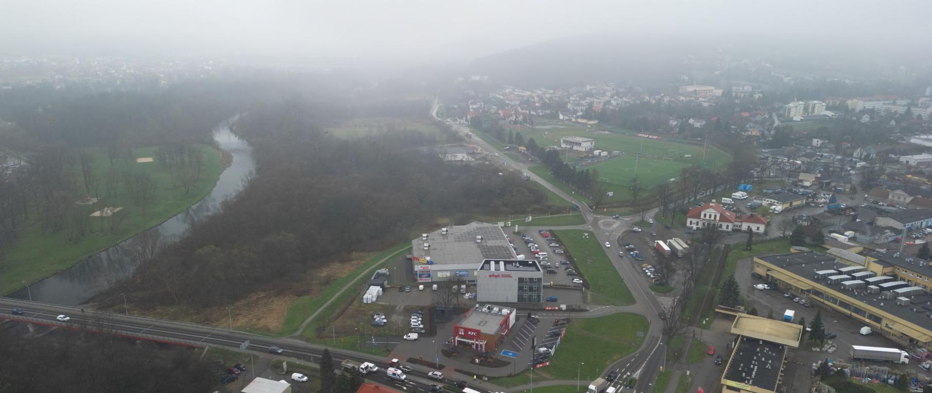 DK28 południowa obwodnica Wadowic, teren budowy przyszłej trasy, na pierwszym planie rondo, w oddali masyw Beskidu Małego, po lewej rzeka Skawa