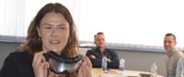 Dzień Bezpieczeństwa i Ochrony Zdrowia w Pracy. Sala konferencyjna Ferm Drobiu Woźniak w Żylicach. W niej uczestnicy konferencji - kierownicy poszczególnych działów firmy, a także przedstawiciele Powiatowej Stacji Sanitarno-Epidemiologicznej w Rawiczu i Państwowej Inspekcji Pracy. Jedna z osób - kobieta testuje autogogle.