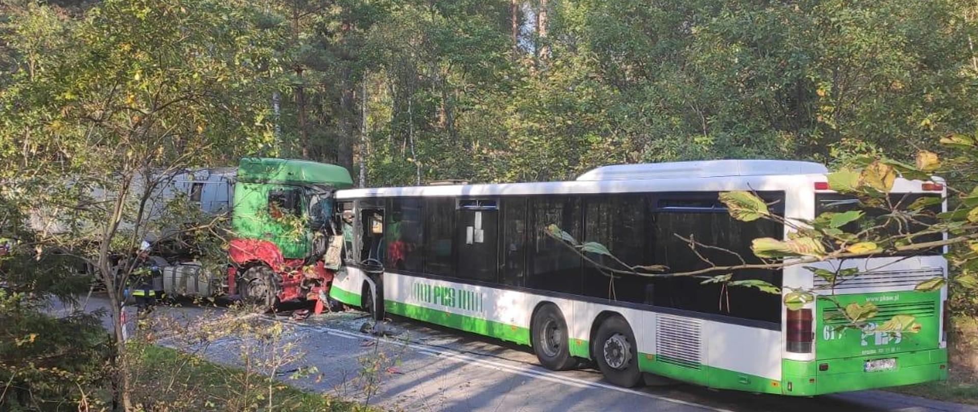 Zdjęcie przedstawia miejsce zdarzenia drogowego z udziałem autobusu i ciężarówki