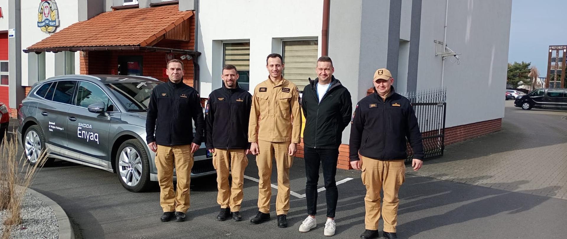 Zdjęcie przedstawia przedstawicieli krotoszyńskich strażaków oraz przedstawiciela salonu motoryzacyjnego, który demonstrował budowę samochodu z napędem elektrycznym na przykładzie pojazdu marki Skoda. Spotkanie miało charakter szkoleniowy.