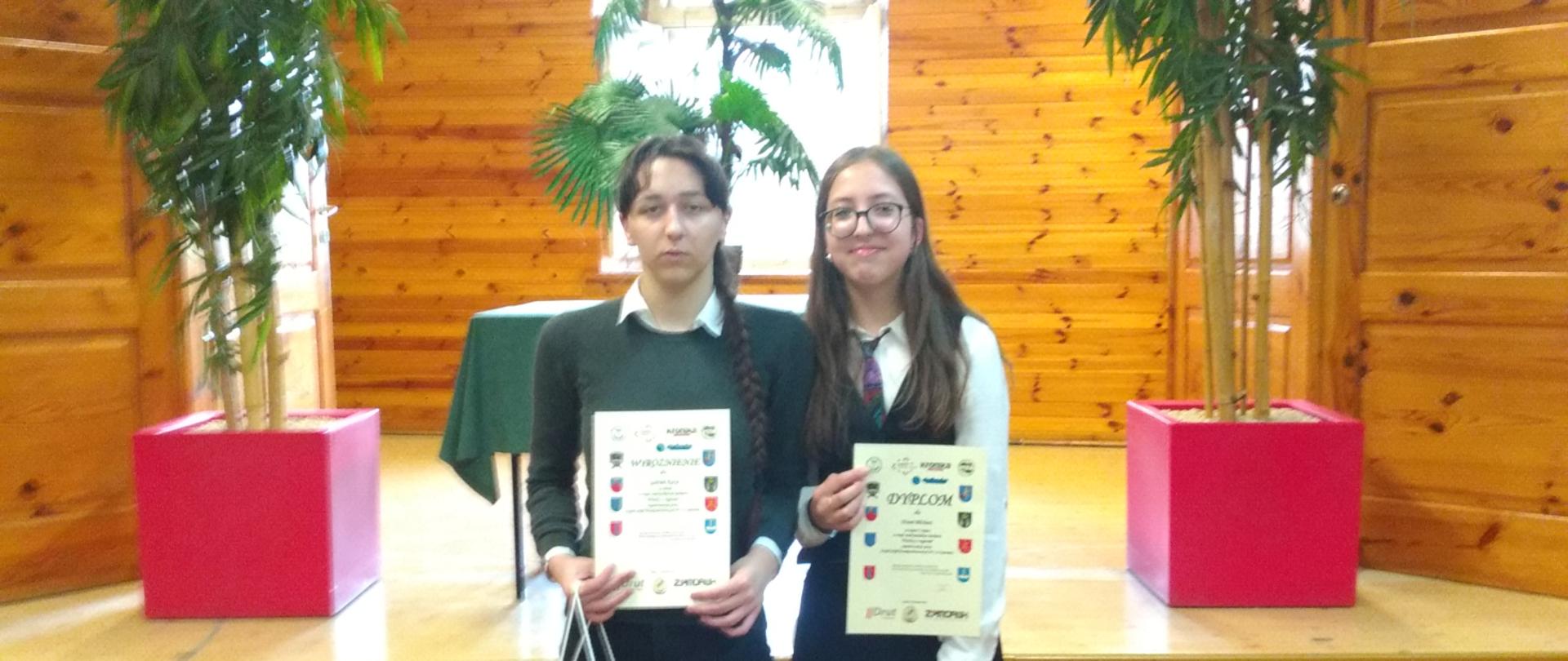 dwie uczennice naszej szkoły z dyplomami i nagrodami z konkursu