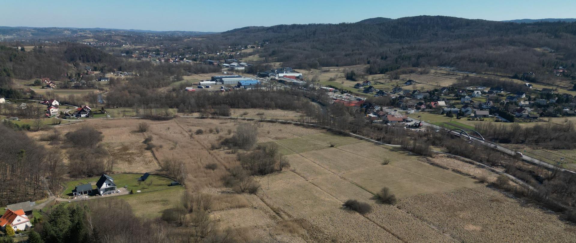 Węzeł Sułkowice, teren budowy przyszłego węzła Sułkowice, widoczne pola, po prawej droga krajowa i zabudowania, w oddali wzgórza