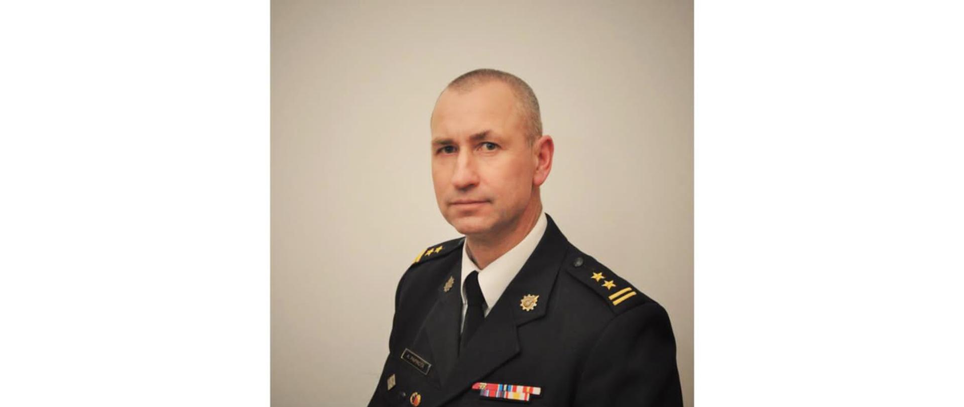 Portret strażaka na szarym tle.