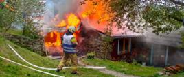 Strażak obok płonącego budynku