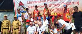 Wspólne zdjęcie udekorowanych zawodników Mistrzostw, wraz ze strażakami oraz gośćmi. W tle banner Mistrzostw.