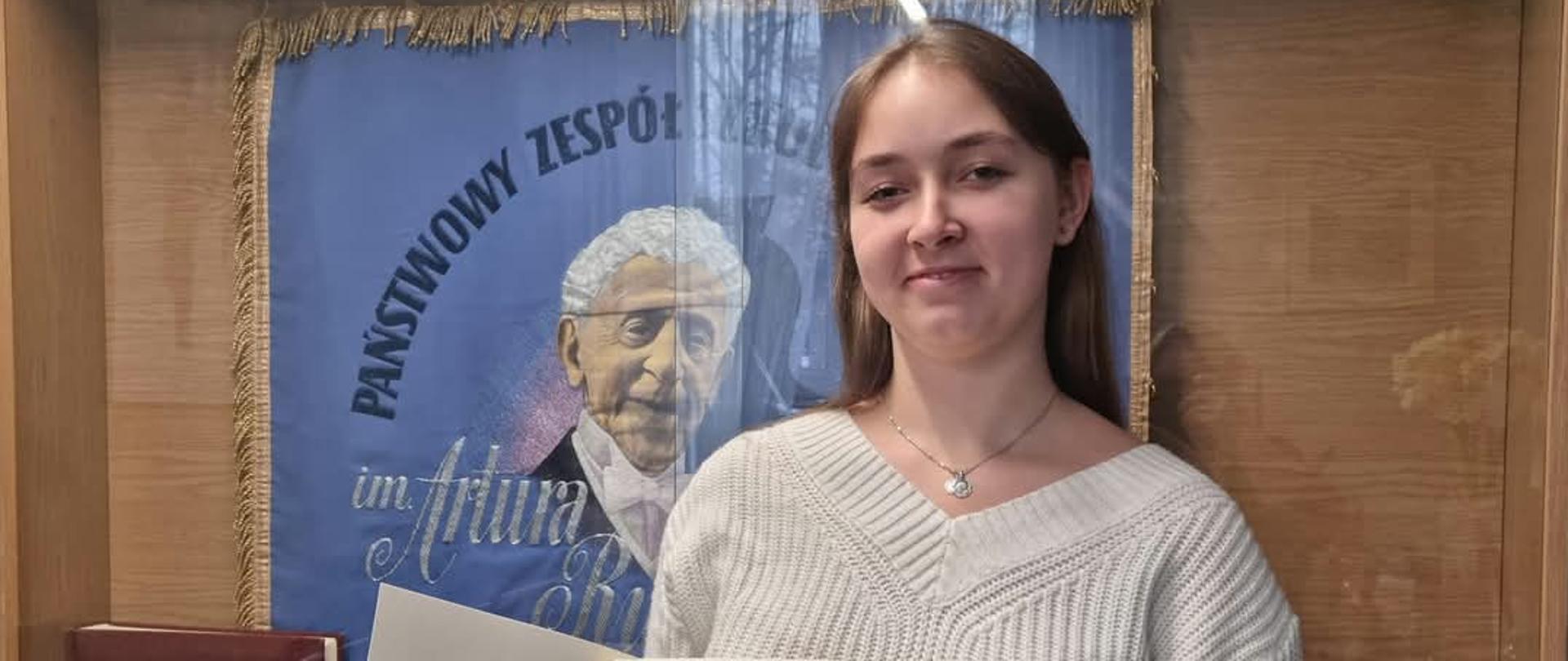 na zdjęciu uczennica z dyplomem