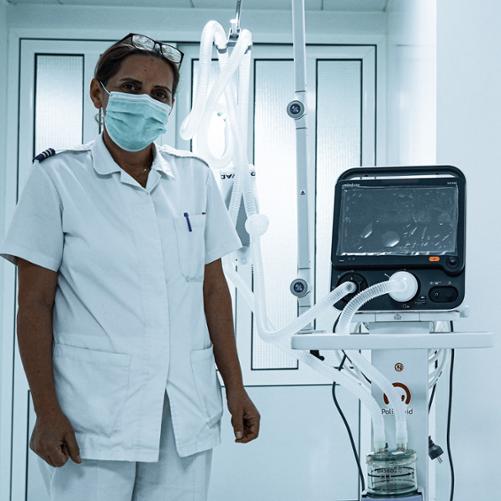 pracownik medyczny stoi obok respiratora oznakowanego naklejką Polish Aid