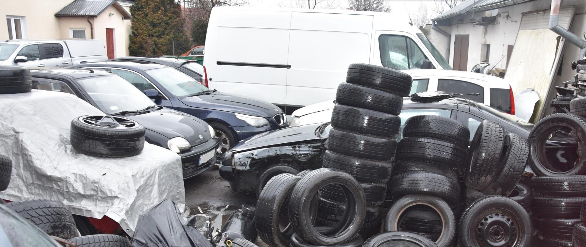 Odpady w postaci opon i innych części samochodowych nielegalnie zgromadzone na otwartym terenie.