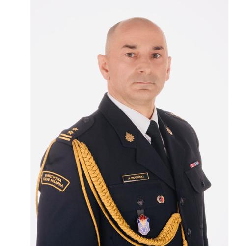 Portret funkcjonariusza Państwowej Straży Pożarnej w mundurze galowym na jasnym tle