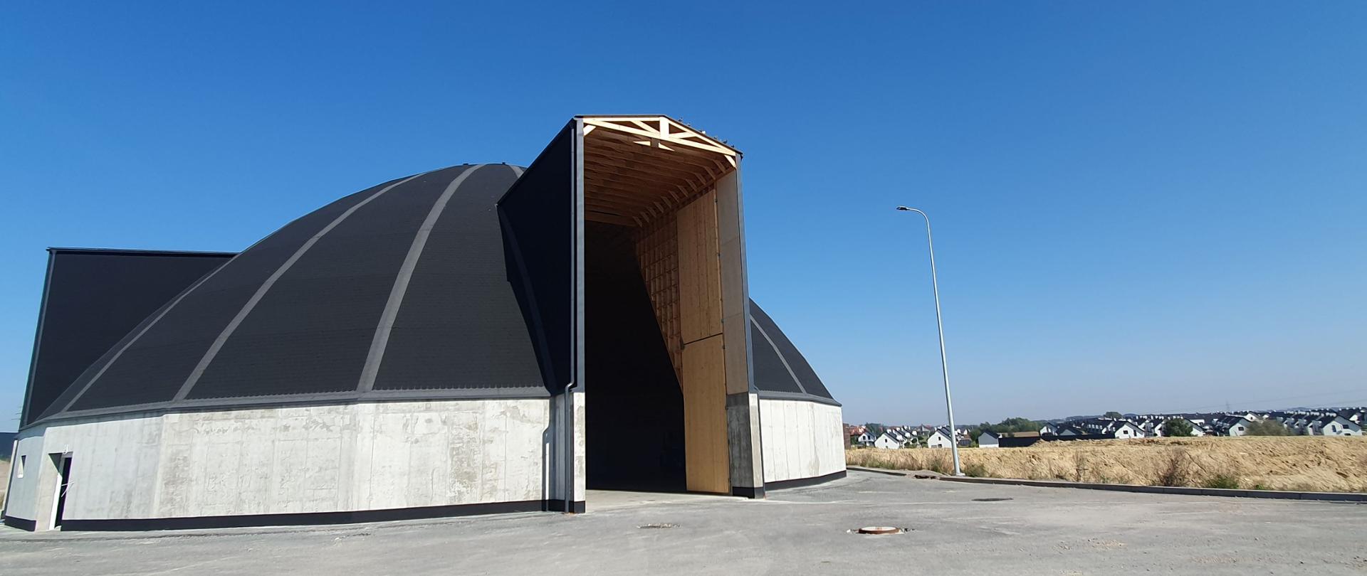 Magazyn na sól drogową nieopodal budowanej S52 Północnej Obwodnicy Krakowa, w oddali osiedle mieszkaniowe