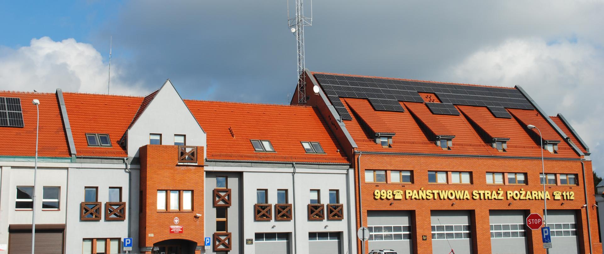 budynek komendy powiatowej PSP w Słupcy z czerwonej cegły kryty dachówka koloru czerwonego na dachu zamontowane panele fotowoltaiczne