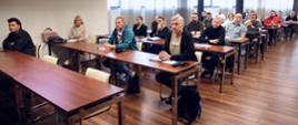 Uczestnicy szkolenia inspektorów ochrony przeciwpożarowej siedzący w ławach sali konferencyjnej podczas zajęć