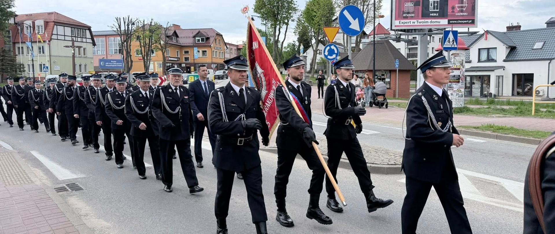 Zdjęcie przedstawia przemarsz strażaków ulicami Sierakowic