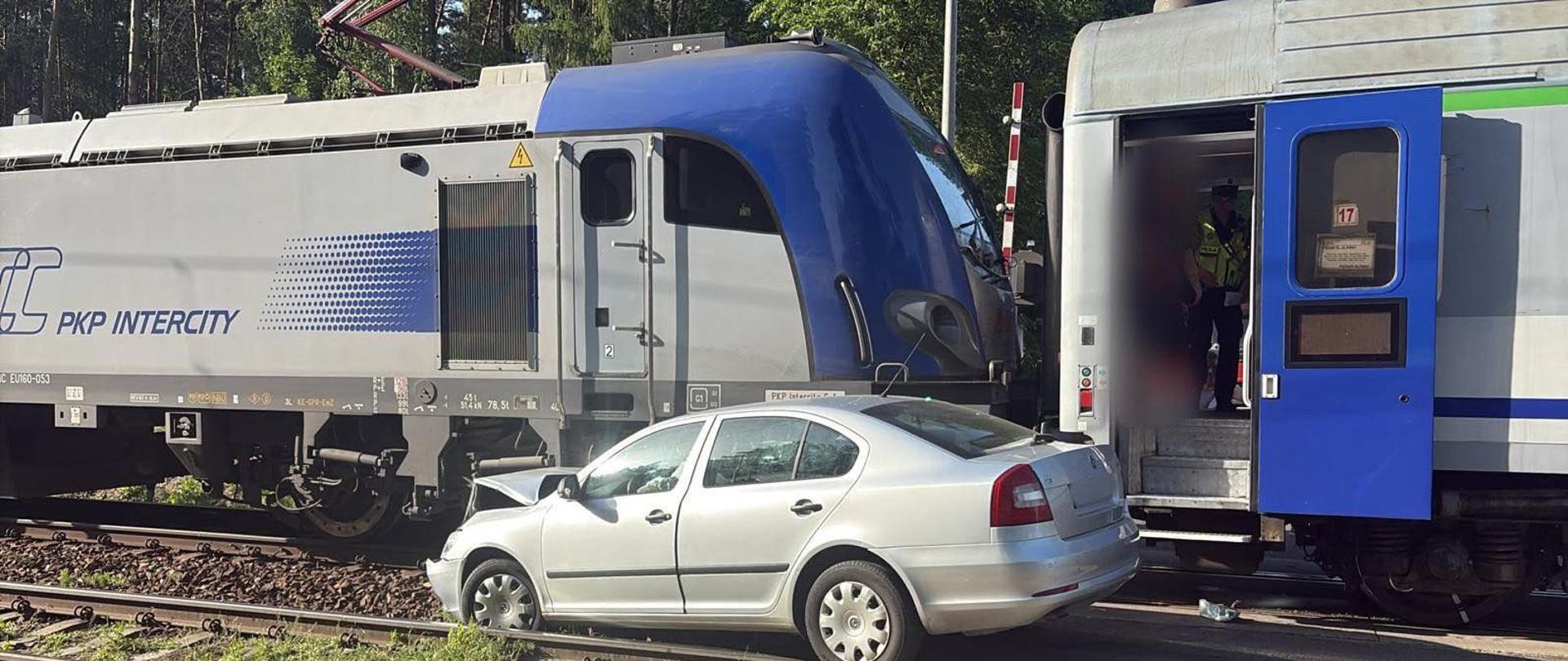 Zdjęcie przedstawia samochód osobowy, który zderzył się z pociągiem na przejeździe kolejowym w Otmicach