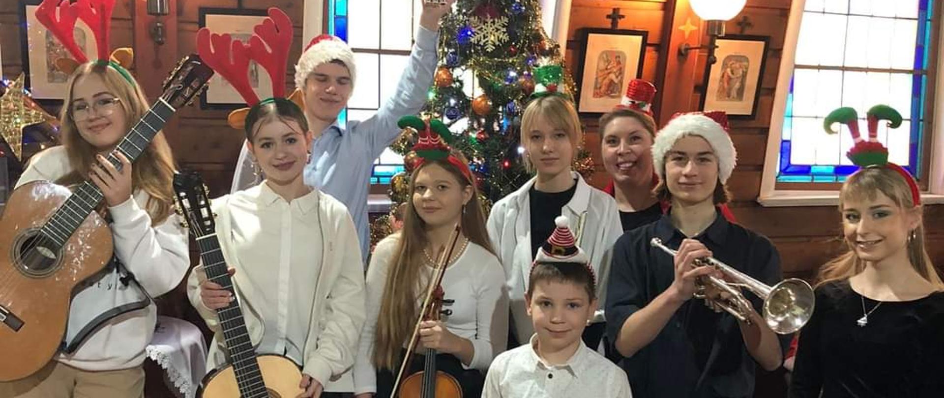 Zdjęcie przedstawia grupę młodych instrumentalistów z nauczycielką.