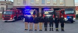 Funkcjonariusze z JRG w Pucku oddają hołd tragicznie zmarłym strażakom, którzy zginęli podczas gaszenia pożaru w Nisku. Ustawieni są w szeregu ubrani w stroje koszarowe. Na drugim planie znajdują się ustawione w szeregu pojazdy pożarnicze. 