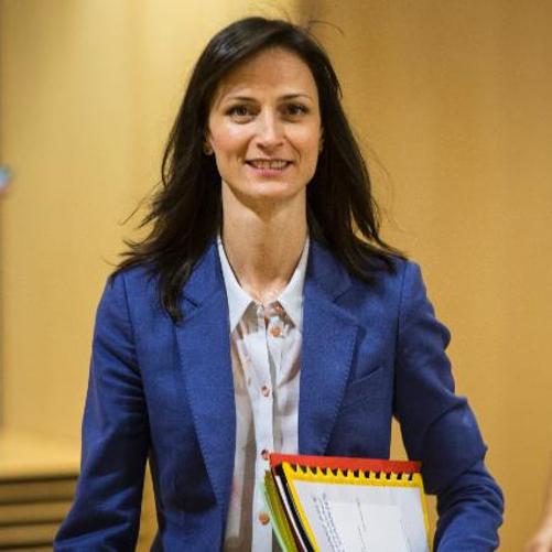 Kobieta w niebieskiej marynarce niosąca dokumenty