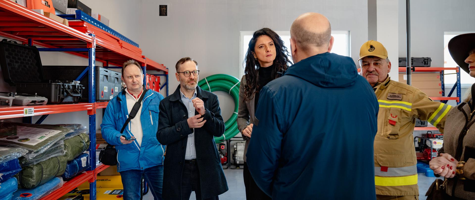 Wojewoda ze strażakami i samorządowcami w magazynie ochrony ludności w Urazie.