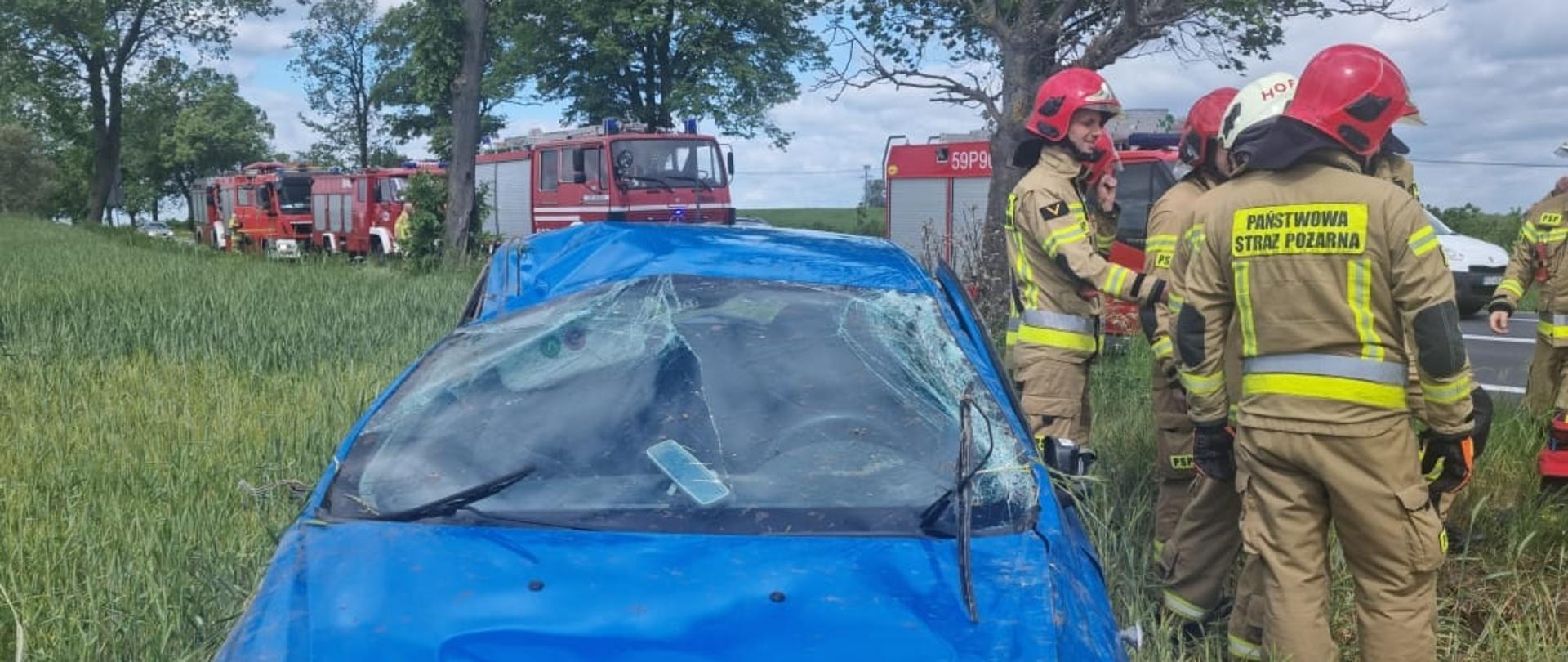Widać samochód na polu, uszkodzony przód i dach