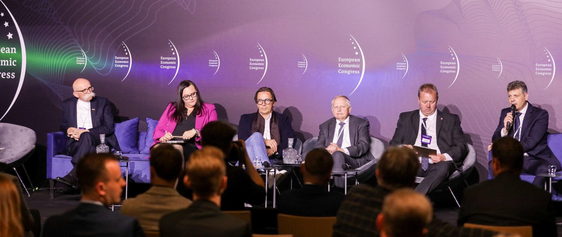 Sześć osób podczas debaty siedzi w sali konferencyjnej na fotelach. Druga z lewej wiceminister Małgorzata Jarosińska-Jedynak. Przed nimi publiczność.