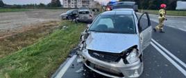 Na zdjęciu widać rozbite pojazdy oraz w tle pojazd straży pożarnej 